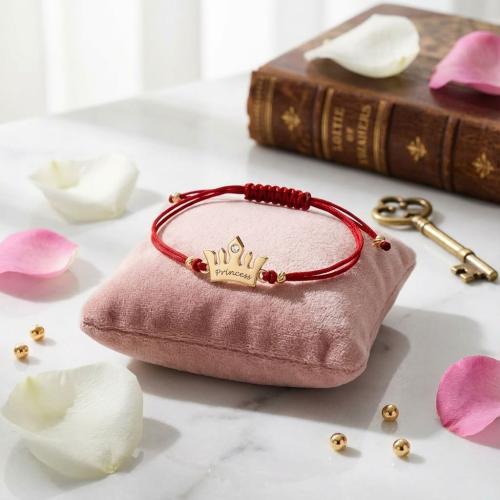 Гривна с червен конец и 14 карата златен елемент корона с гравирано послание