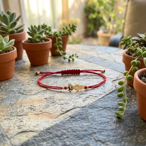 Гривна с червен конец и 14 карата златен елемент момиченце