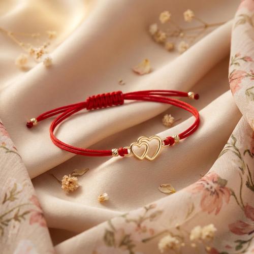 Гривна с червен конец и златен елемент две сърца