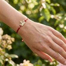 Гривна с червен конец и 14 карата златен елемент корона с гравирано послание