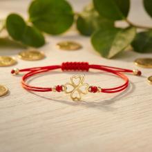 Гривна с червен конец и 14 карата златен елемент детелинка