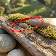 Гривна с червен конец и 14 карата златен елемент детелинка