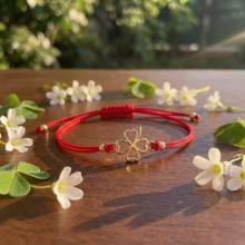 Гривна с червен конец и 14 карата златен елемент детелинка