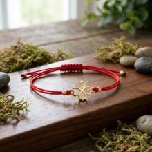 Гривна с червен конец и 14 карата златен елемент детелинка