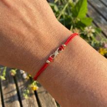 Гривна с червен конец и 14 карата златен елемент безкрайност Гривна с червен конец и 14 карата златен елемент безкрайност