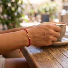 Гривна с червен конец и 14 карата златен елемент безкрайност Гривна с червен конец и 14 карата златен елемент безкрайност