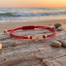 Гривна с червен конец и 14 карата златен елемент безкрайност Гривна с червен конец и 14 карата златен елемент безкрайност