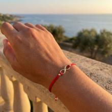 Гривна с червен конец и 14 карата златен елемент безкрайност Гривна с червен конец и 14 карата златен елемент безкрайност