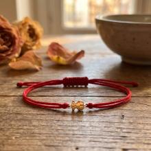 Гривна с червен конец и 14 карата златен елемент мече Гривна с червен конец и 14 карата златен елемент мече