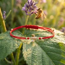 Гривна с червен конец и 14 карата златен елемент пчеличка