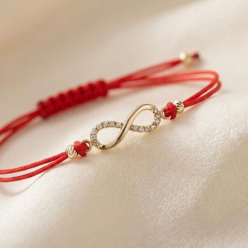 Гривна с червен конец и златен елемент безкрайност