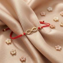 Гривна с червен конец и златен елемент безкрайност