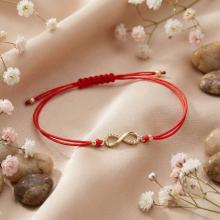 Гривна с червен конец и златен елемент безкрайност