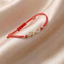 Гривна с червен конец и златен елемент безкрайност