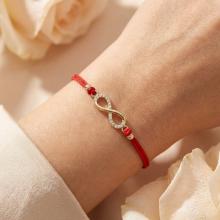 Гривна с червен конец и златен елемент безкрайност