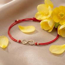 Гривна с червен конец и златен елемент безкрайност