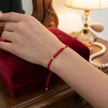 Гривна с червен конец и 14 карата златни топчета