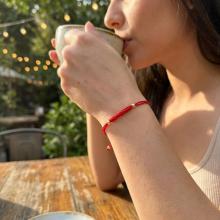 Гривна с червен конец и 14 карата златни топчета