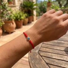 Гривна с червен конец и златен елемент синьо око