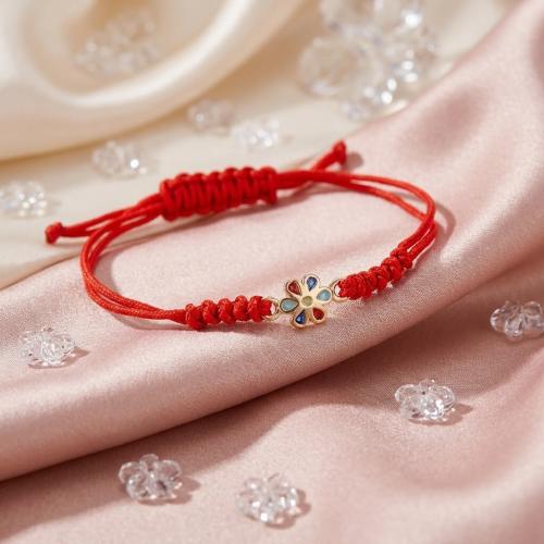 Гривна с червен конец и златен елемент цвете