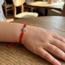 Гривна с червен конец и златен елемент цвете Гривна с червен конец и златен елемент цвете