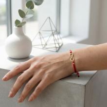 Гривна с червен конец и 14 карата златен елемент безкрайност Гривна с червен конец и 14 карата златен елемент безкрайност