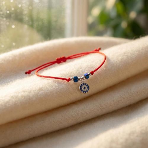 Гривна с червен конец с Dark Heliotrope и сребърен елемент синьо око