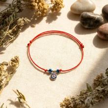 Гривна с червен конец с Dark Heliotrope и сребърен елемент синьо око