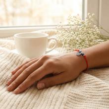 Гривна с червен конец с Dark Heliotrope и сребърен елемент синьо око