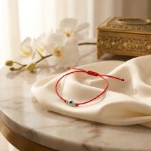 Гривна с червен конец златни топчета и синьо око