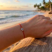 Гривна с червен конец златни топчета и синьо око