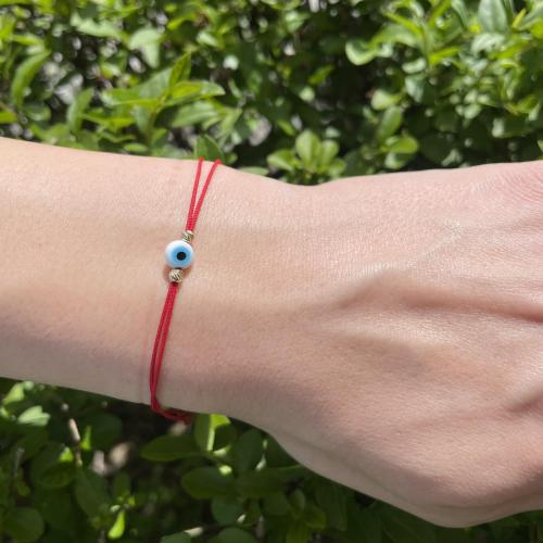 Гривна с червен конец златни топчета и синьо око